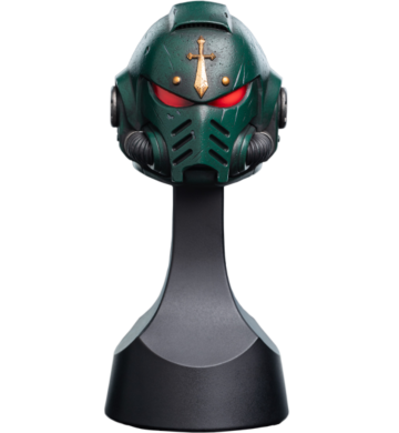 A green futuristic helmet with red eye slits and a gold cross emblem on the forehead, reminiscent of Warhammer 40k's Space Marine Helmet Replicas, is displayed on a black stand. Crafted by Weta Workshop, the design boasts intricate detailing and a vented mouthpiece.